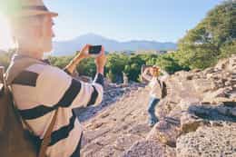 Man taking photo of woman at Greek ruins.